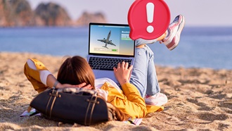 chica en la playa viendo en su portátil ofertas de vuelos